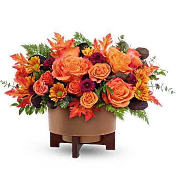 Orange and purple floral arrangement in a low container
