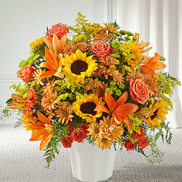 Orange and yellow mixed bouquet in a white vase