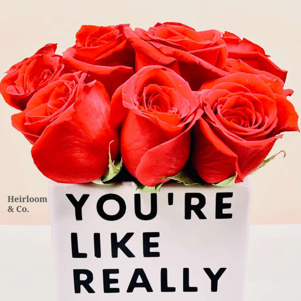 Red roses in a white box with bold black text