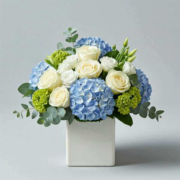 Blue hydrangeas and white roses in a white vase