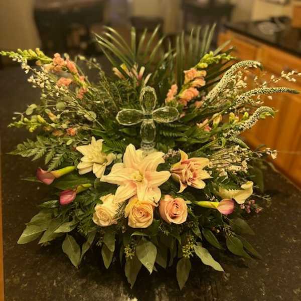 Large floral arrangement with lilies and roses in a low container