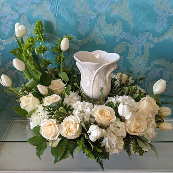 White floral arrangement with roses and tulips in a white vase