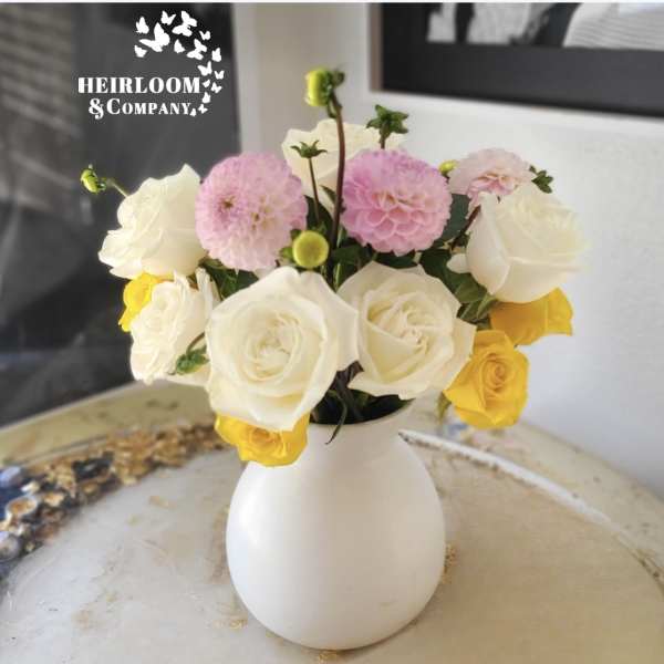 White, pink, and yellow roses in a white vase