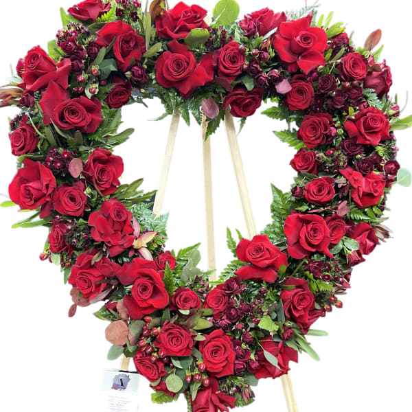 Heart-shaped red rose wreath on a wooden easel