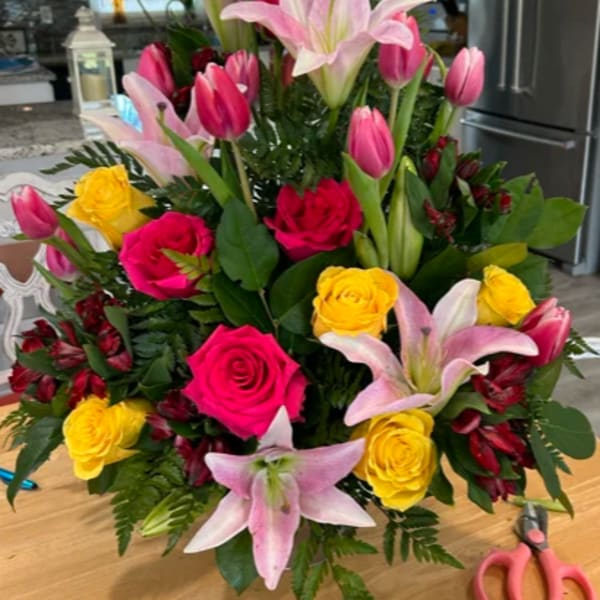 Pink lilies, roses, tulips, and yellow roses in a large bouquet