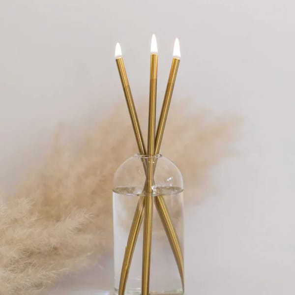 Clear glass vase with three gold reed diffusers