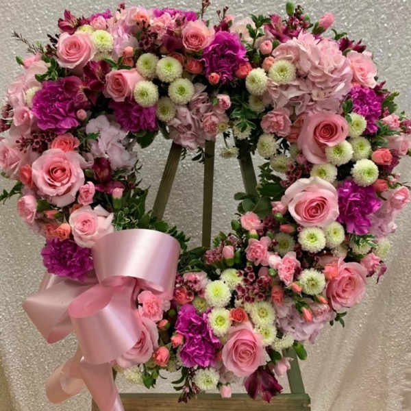 Pink and purple floral wreath with a satin ribbon on an easel