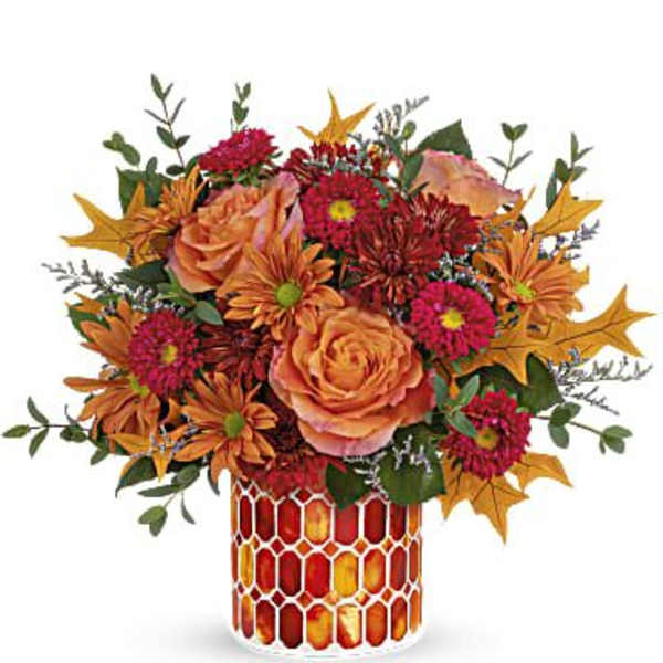 Autumn bouquet of orange and red flowers in a patterned vase