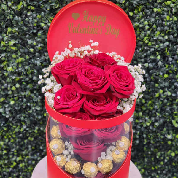 Red roses in a round gift box with chocolates and a Happy Valentine's Day lid