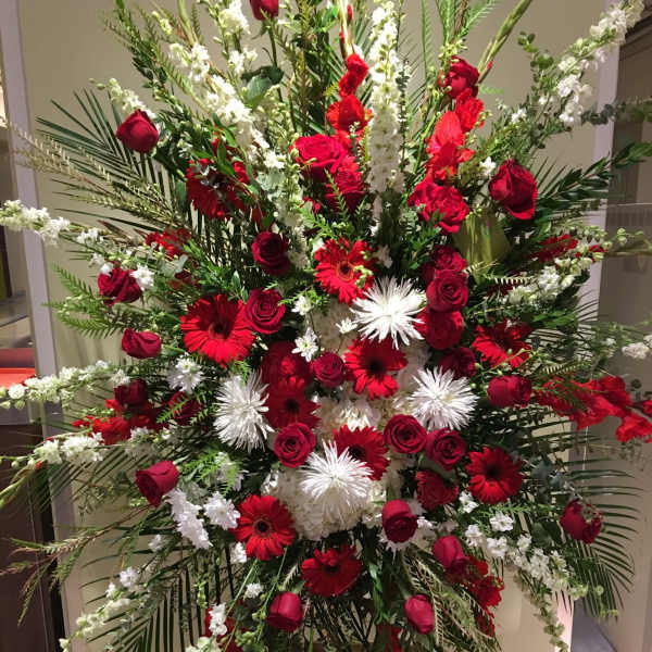Large red and white floral standing spray with roses and gerbera daisies