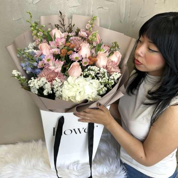 Large bouquet of pink and white flowers in mauve wrapping