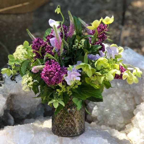 Mixed bouquet in a textured glass vase with purple, lavender, and yellow blooms
