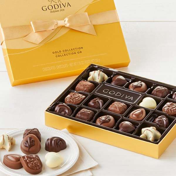 Box of assorted chocolates with a yellow gift box and ribbon