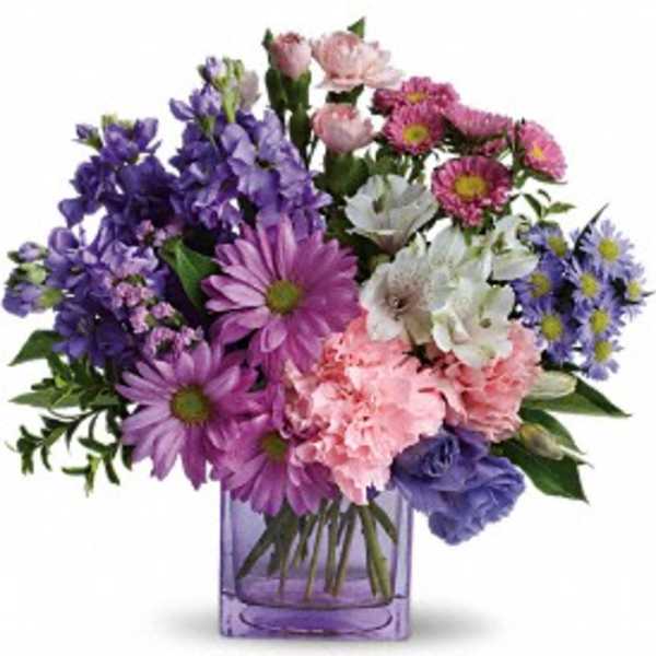 Mixed purple and pink flowers in a purple glass vase