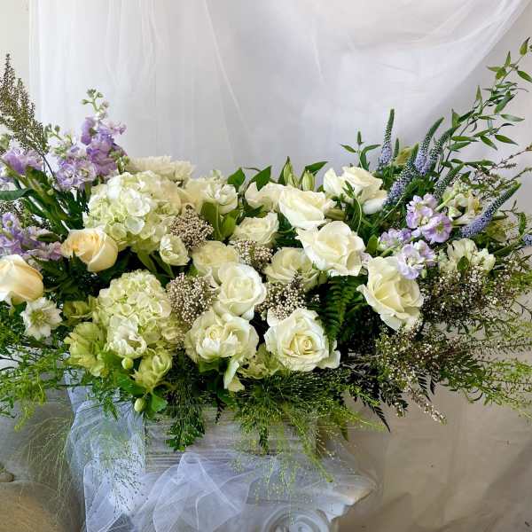 Large white and lavender floral arrangement in a vase