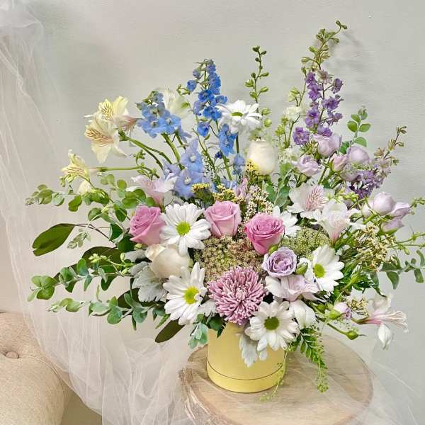Pastel mixed flower arrangement in a yellow vase