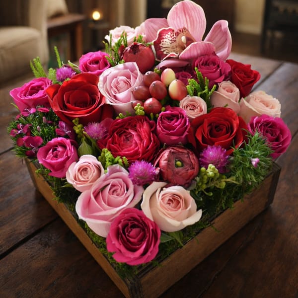 Heart-shaped box filled with pink and red roses and orchids