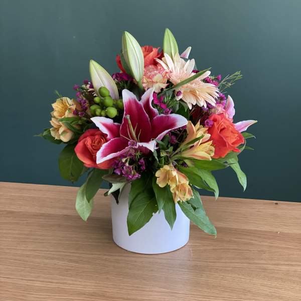 Mixed bouquet with lilies and roses in a white vase