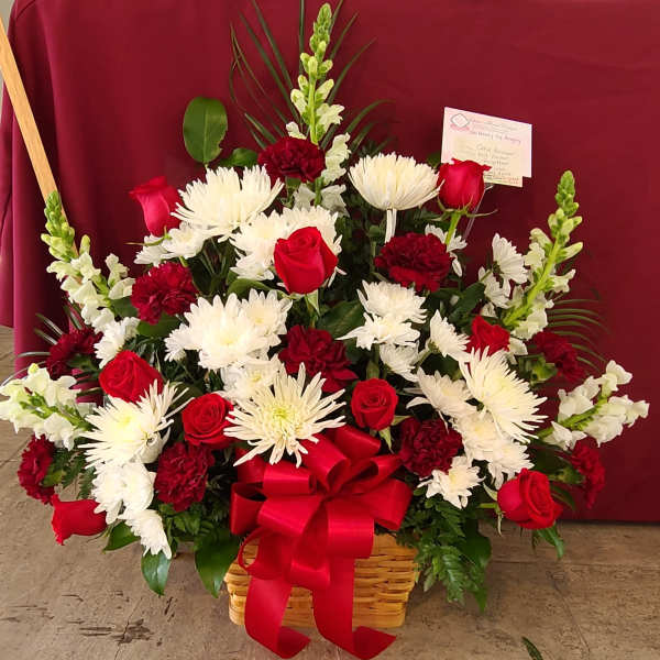 Red roses and white chrysanthemums in a basket with a red bow