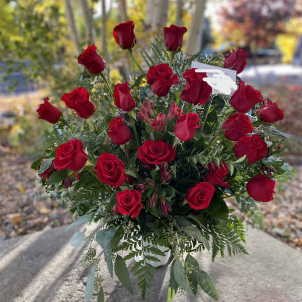 Bouquet of red roses with greenery in a white vase