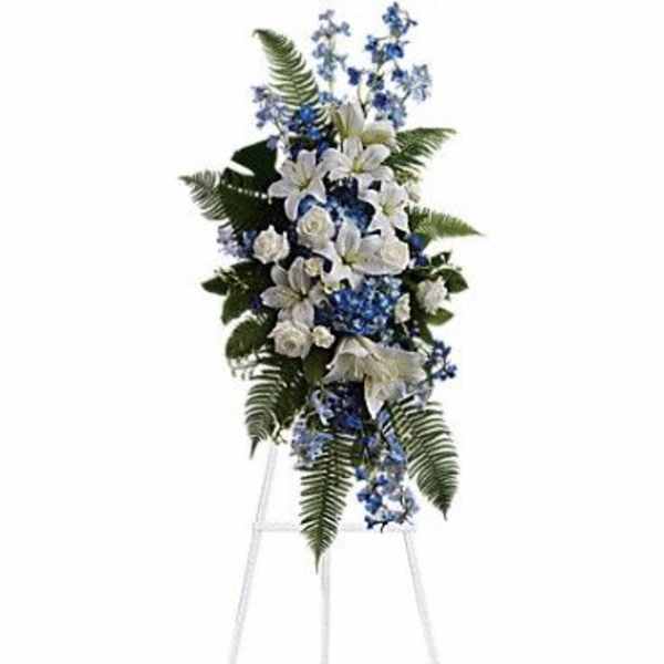 White and blue funeral spray on a standing easel