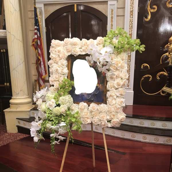 Large floral easel display of white roses and orchids