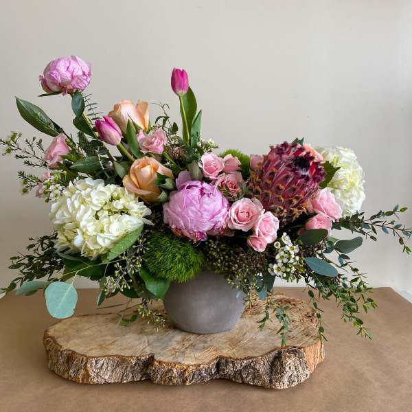 Mixed pink and white floral arrangement in a gray vase