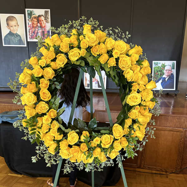Large yellow rose funeral wreath on a standing easel