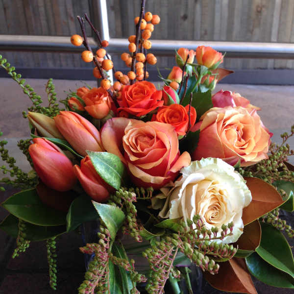 Orange and cream rose bouquet with tulips and berry branches