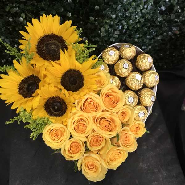 Heart-shaped bouquet of yellow roses and sunflowers with gold chocolates