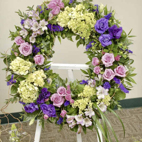Floral wreath with pink and purple roses on a white easel