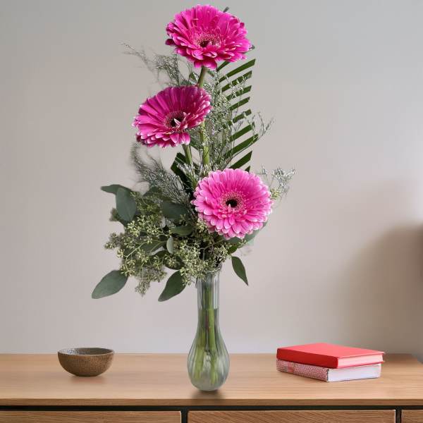Tall bouquet of pink gerbera daisies in a glass vase