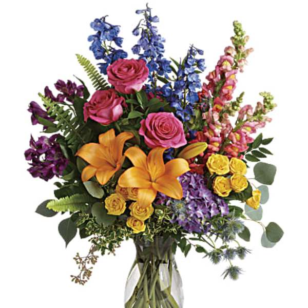 Colorful bouquet of roses, lilies, and snapdragons in a glass vase