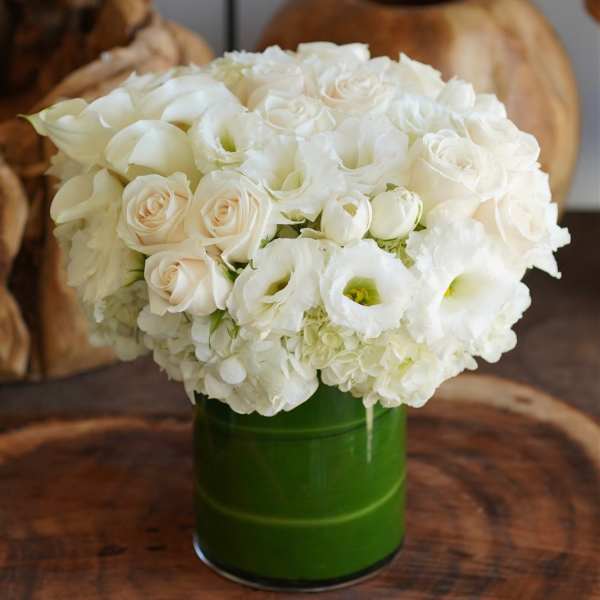 White roses and lisianthus in a green vase