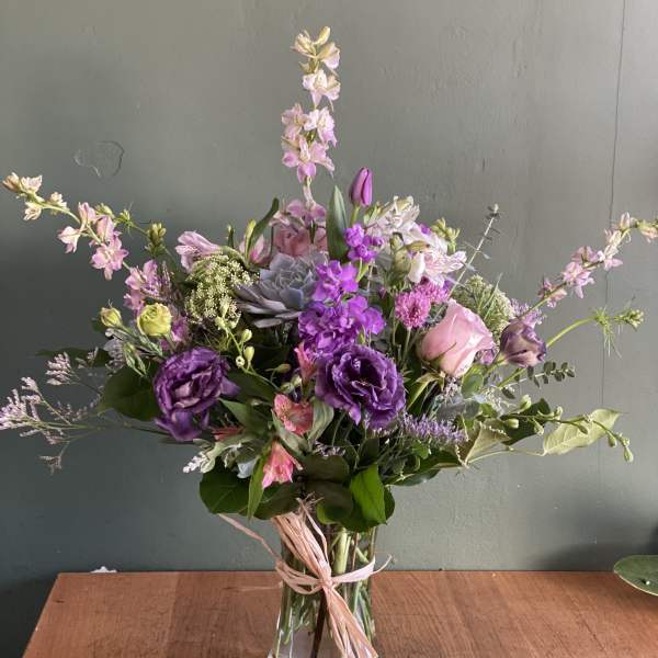 Purple and pink mixed bouquet in a clear glass vase
