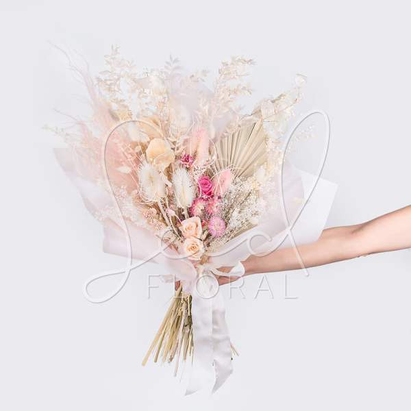 Pastel bouquet with pink and cream flowers wrapped in white paper