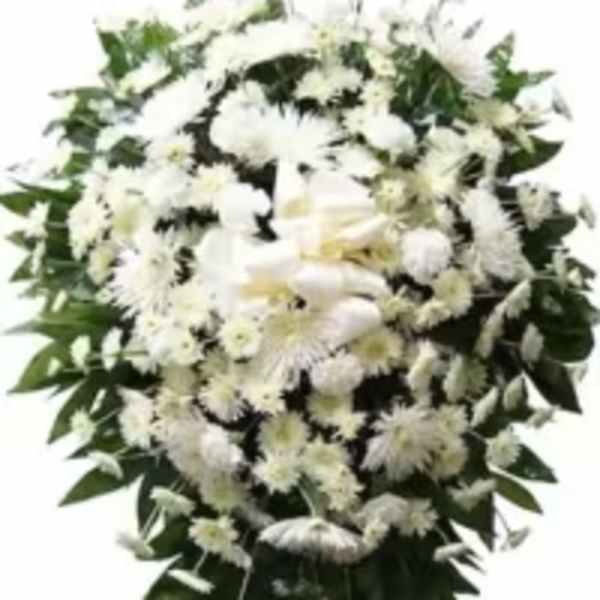Standing spray of white chrysanthemums and daisies with a white bow