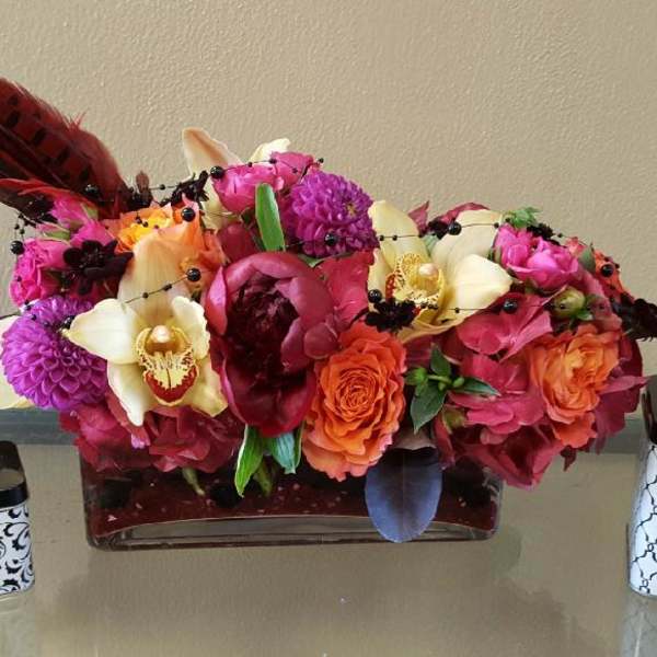 Bright mixed flower arrangement with decorative jars on a table