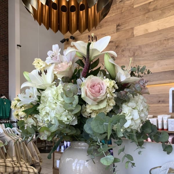 Large white and blush floral arrangement in a ceramic vase