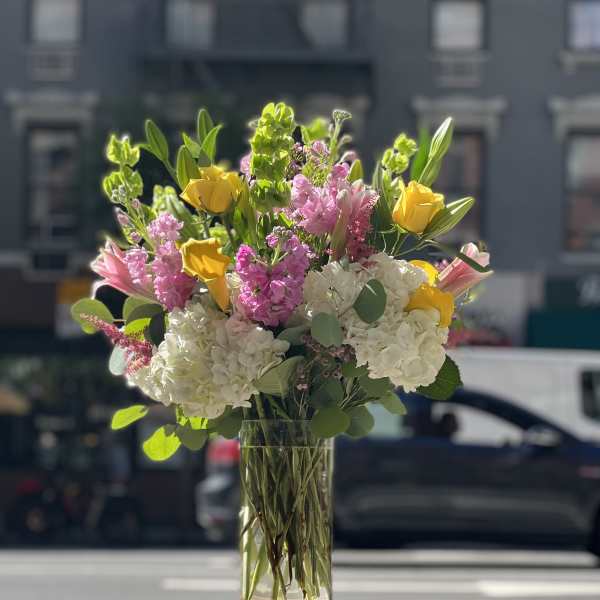 Bouquet of pink, white, and yellow flowers in a clear glass vase