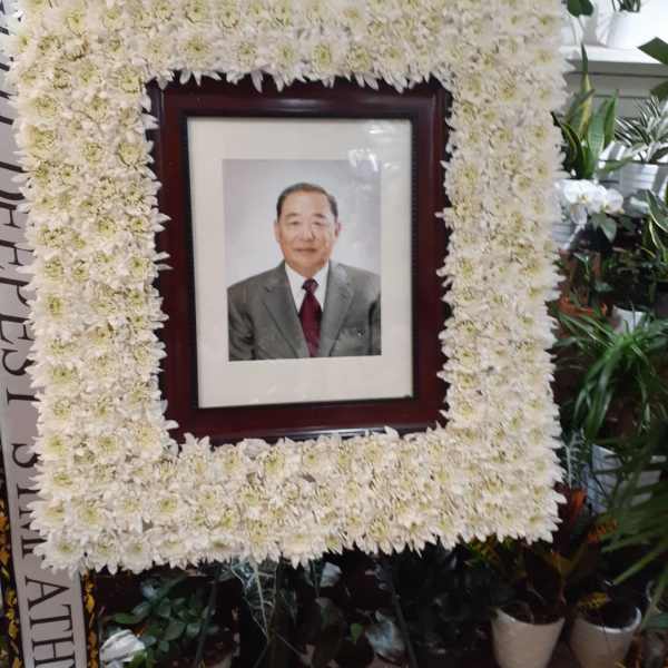 White chrysanthemum funeral frame surrounding a portrait