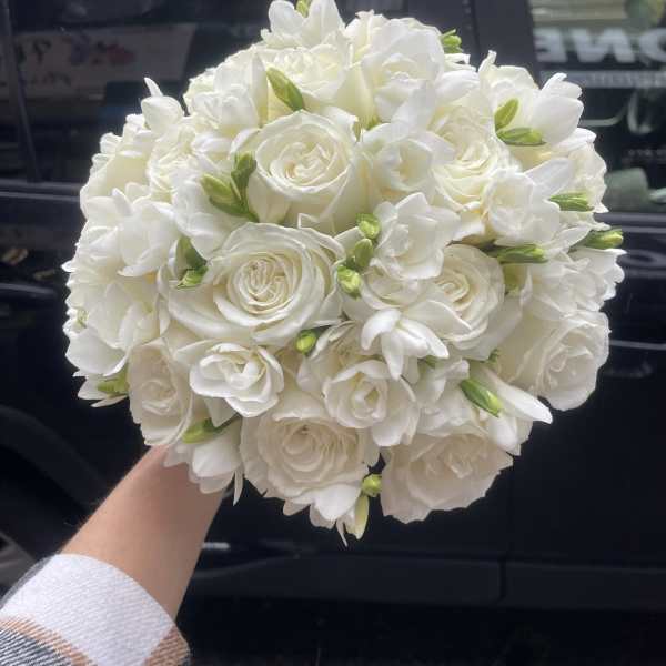 Round bouquet of white roses and white freesia