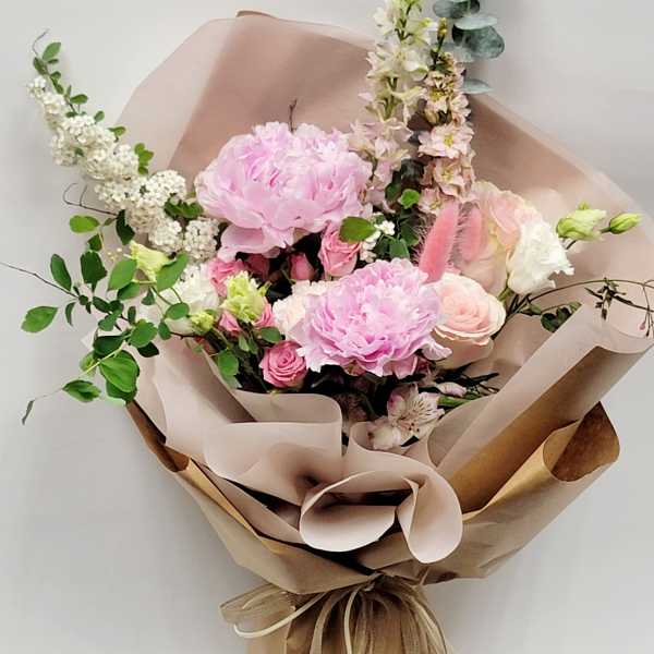 Pink and white mixed bouquet wrapped in brown paper