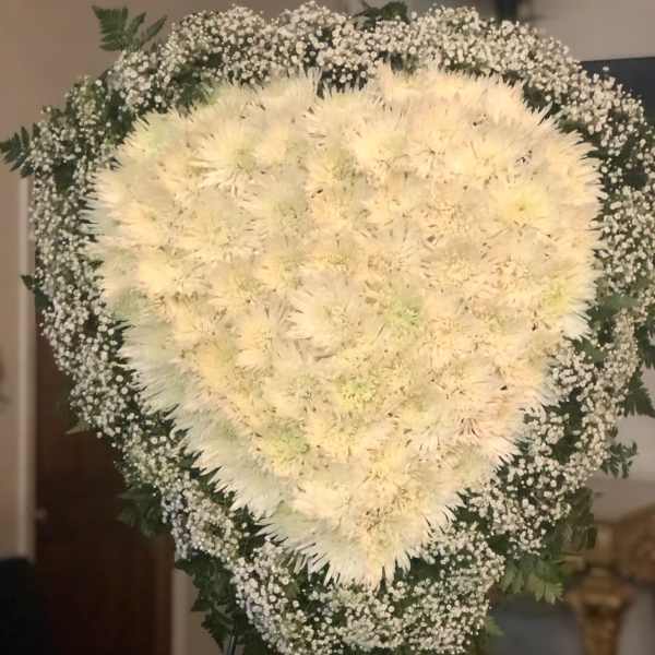 Heart-shaped white floral standing spray with baby's breath border