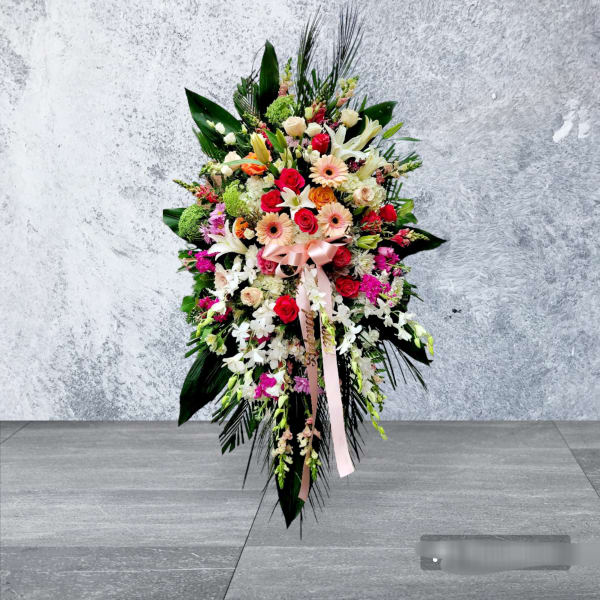 Large standing floral spray with roses, lilies, and gerbera daisies
