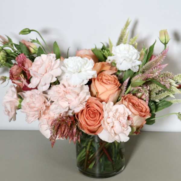Peach and blush bouquet in a glass vase