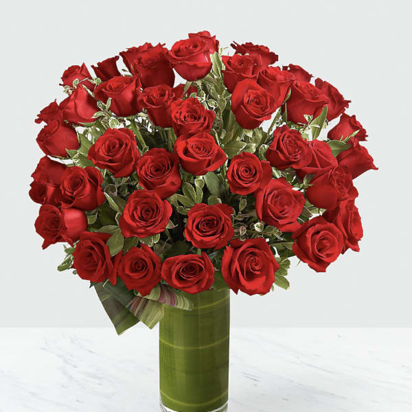 Bouquet of red roses in a tall glass vase