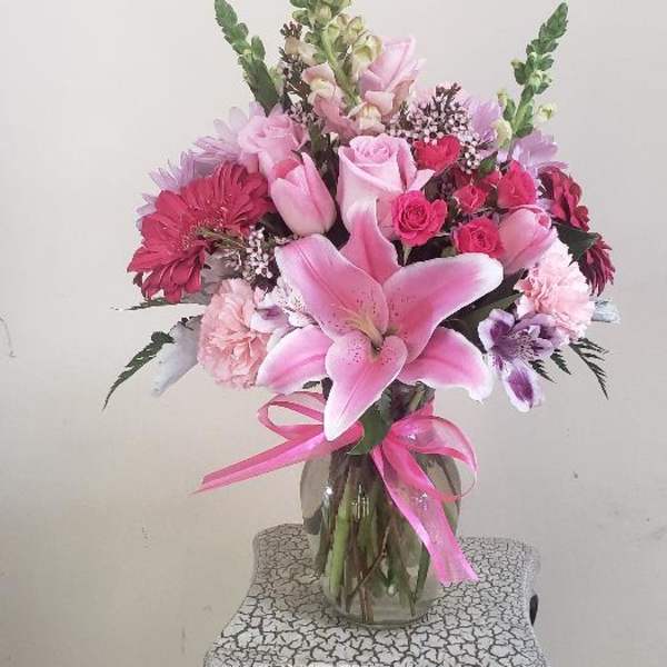 Pink mixed bouquet in a glass vase with a ribbon