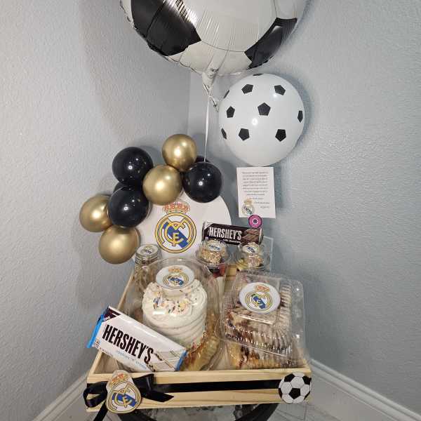 Soccer-themed balloon and dessert gift tray with a cake and chocolates