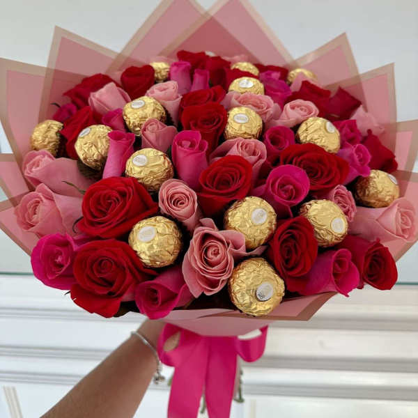 Bouquet of red and pink roses with gold-wrapped chocolates